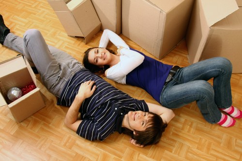 Movers carrying furniture through a Dalston flat staircase