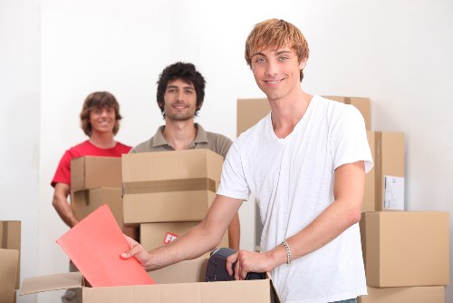 Removalists carrying household items down stairs in Dalston